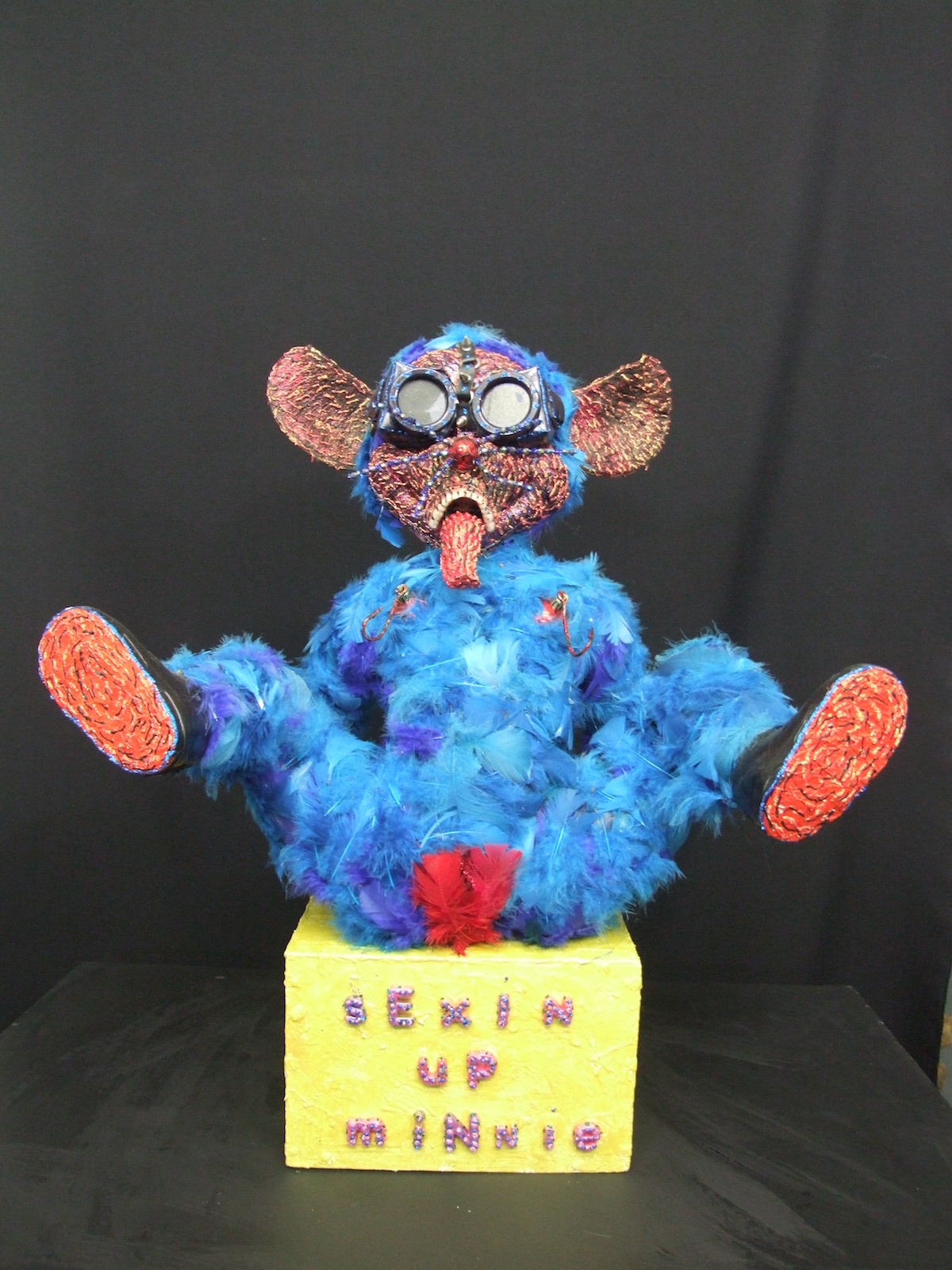 " Sexin' Up Minnie '' from the series, ' My little people that have come down from the hills....' Medium Mixed Media ------ created from found objects, put together in my ' Frankenstein ' way, then dressed and highly decorated, including layers of feathers, paint, altered objects, plus some inspiration....... Size 26 inches / 66 centimetres tall, plus plinth seat